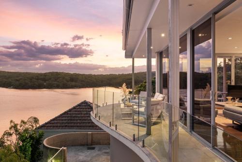 a house with a balcony with a view of a river at Tranquil Retreat at Caringbah South - Waterfront Ensuite King Room with Spectacular Views in Lilli Pilli