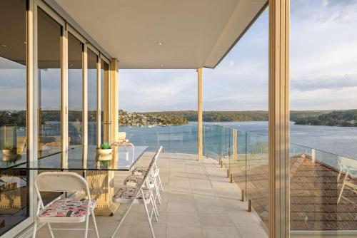a balcony with chairs and a view of the water at Tranquil Retreat at Caringbah South - Waterfront Ensuite King Room with Spectacular Views in Lilli Pilli