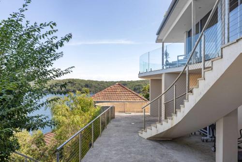 a balcony of a house with a view of the water at Tranquil Retreat at Caringbah South - Waterfront Ensuite King Room with Spectacular Views in Lilli Pilli