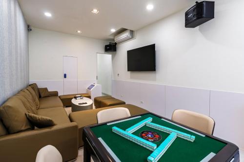 a living room with a ping pong table and a tv at SMilE WAVE in Xiaoliuqiu