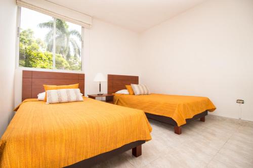 カリにあるApartamento Cali Camino Realのベッド2台と窓のある寝室