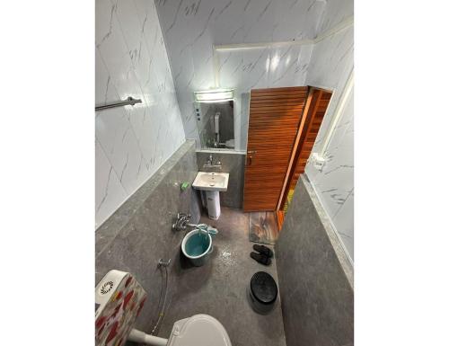 a bathroom with a sink and a toilet and a mirror at Global Hotel & Restaurant, Gulmarg in Gulmarg