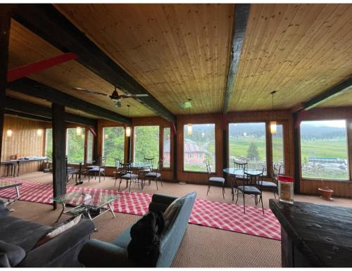 a large room with chairs and tables and windows at Global Hotel & Restaurant, Gulmarg in Gulmarg