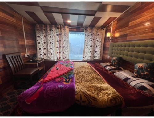 a bedroom with a large bed and a window at Global Hotel & Restaurant, Gulmarg in Gulmarg