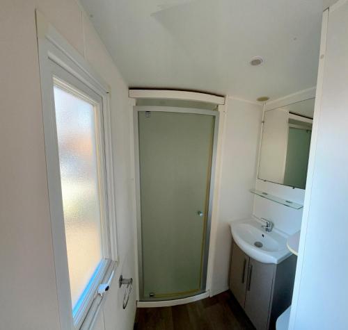 une petite salle de bain avec un lavabo et un miroir dans l'établissement Vias Mobil home 6-8 pers tout confort climatisé, à Vias