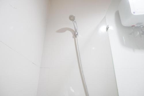 a shower in a bathroom with a shower head at Comfort 2BR at Tree Park City BSD Apartment By Travelio in Tangerang