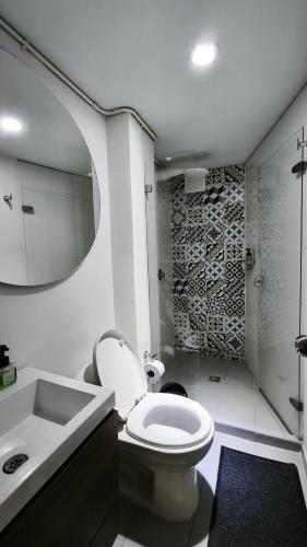 a bathroom with a toilet and a sink and a mirror at Hermoso apartaestudio Zona Rosa de Milan in Manizales