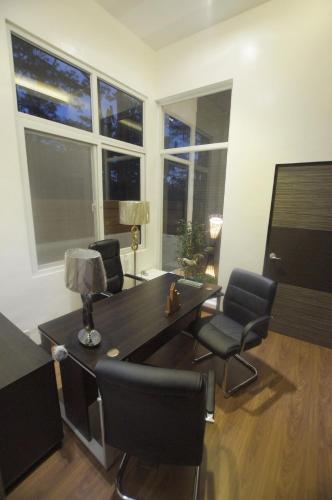 a living room with a table and chairs and windows at One house UNIT 1 Your Luxury home in Baguio