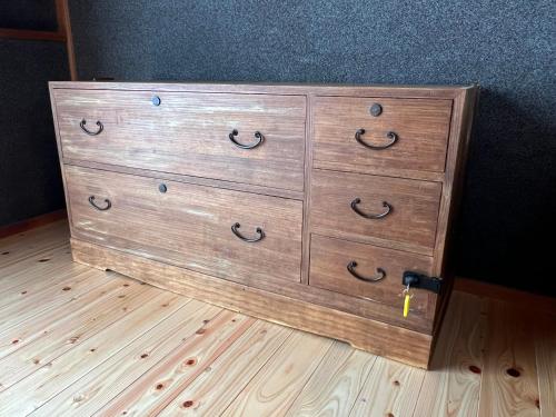 a wooden dresser sitting on top of a wooden floor at Guesthouse Usagi in Kumano