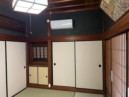 a room with four white doors and a ceiling at Guesthouse Usagi in Kumano