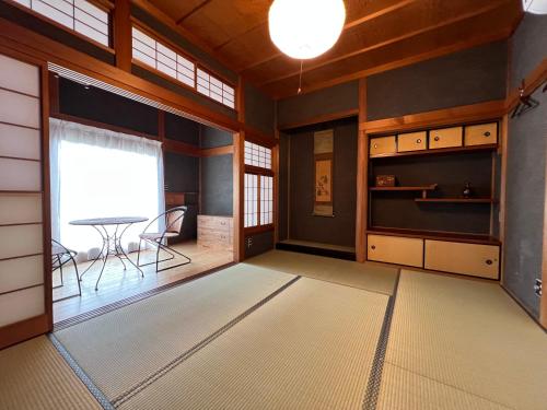 a room with a table and a dining room at Guesthouse Usagi in Kumano