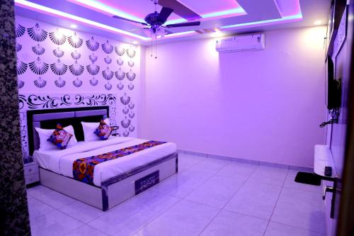 a bedroom with a bed in a room with purple lights at JMC Hotel RK Inn in Dakan Kotra