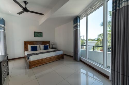 a bedroom with a bed and a large window at Oceanfront Condominium - Nilaveli in Nilaveli
