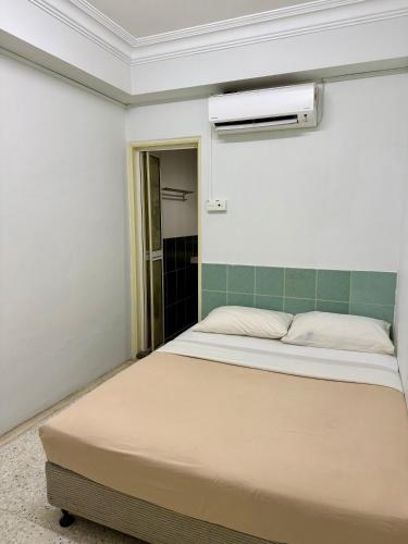 a bedroom with a bed and a air conditioner at Eco Stay Guesthouse in Kuantan