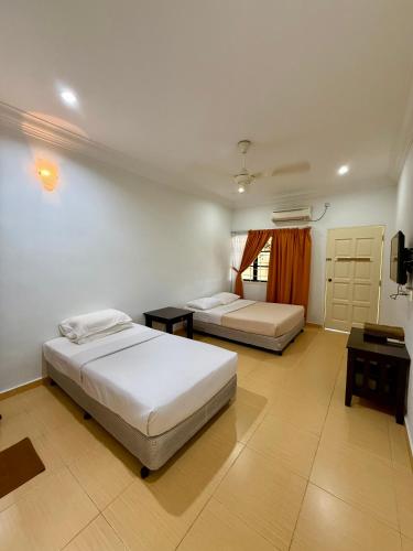 a bedroom with two beds and a window at Eco Stay Guesthouse in Kuantan
