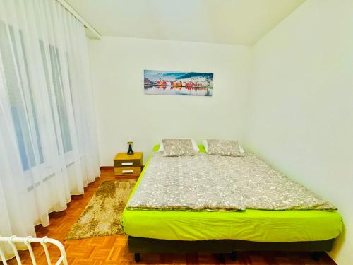 a bedroom with a green bed in a room at ApartaHotel L'escapade Urbaine in Lausanne