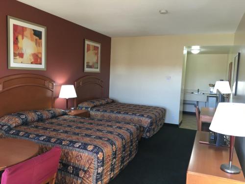 a hotel room with two beds and a table at Western Valley Inn in Valleyview