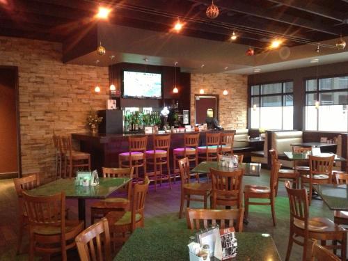 a restaurant with tables and chairs and a bar at Western Valley Inn in Valleyview