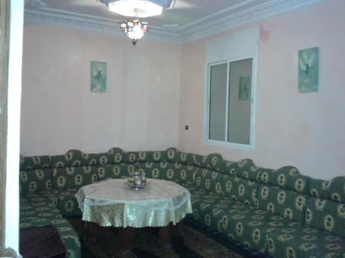 a living room with a couch and a table at Elmenzah Apartments in Taroudant
