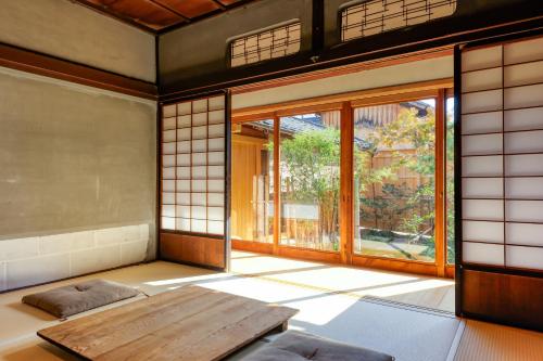 a room with a wooden table and a large window at NIPPONIA HOTEL 伊賀上野 城下町 in Iga