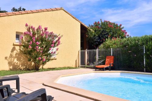 a swimming pool in a yard with a chair at Villa Spacieuse au Calme Absolu avec Grande Piscine Jacuzzi Chauffé - Grand Jardin Sans Vis a vis- Salle de Jeux avec Fresque du Nougat - Ideal Familles et Groupes Drome Provencale in Montélimar