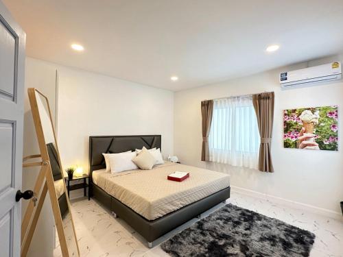 Un dormitorio pequeño con una cama y una ventana. en liwei cozy pool villa, en Pattaya South
