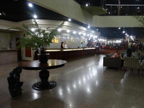 un vestíbulo con una mesa con una planta en Taj Mahal Hotel, en Manaus