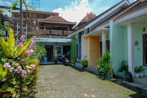 a courtyard of a house with flowers and plants at RedDoorz Gita Grha Prawirotaman in Yogyakarta