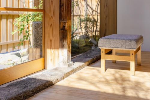 a stool sitting in front of a window at NIPPONIA HOTEL 伊賀上野 城下町 in Iga