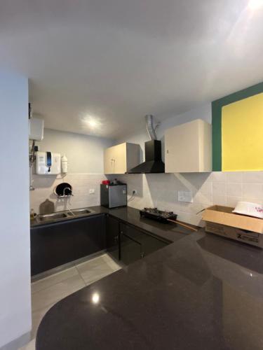a kitchen with black counter tops and white cabinets at Valley View 1 BHK with Room Service in Solan