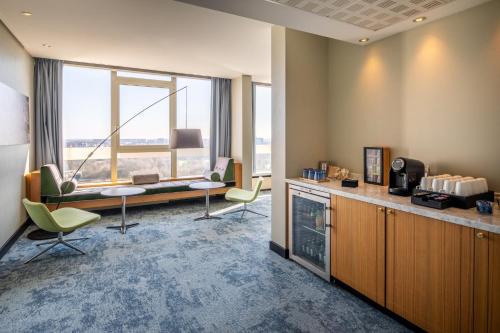 an office with a desk and chairs and a large window at Crowne Plaza Antwerpen by IHG in Antwerp