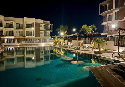 a swimming pool in front of a building at night at Cosmos Residence in Paralimni