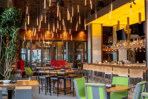 a restaurant with tables and chairs and a bar at Hilton Garden Inn Louisville Downtown in Louisville
