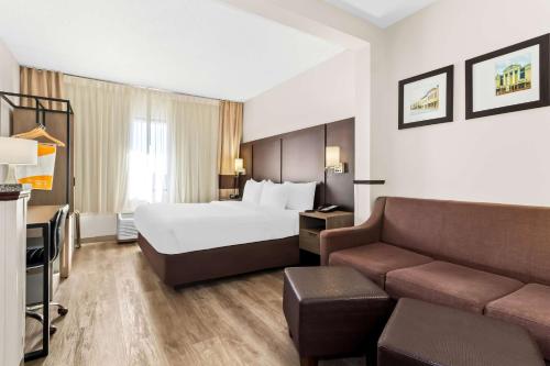 a hotel room with a bed and a couch at Comfort Suites Lumberton North in Lumberton