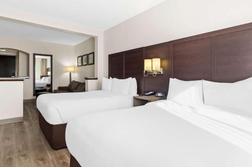 a hotel room with two beds and a living room at Comfort Suites Lumberton North in Lumberton