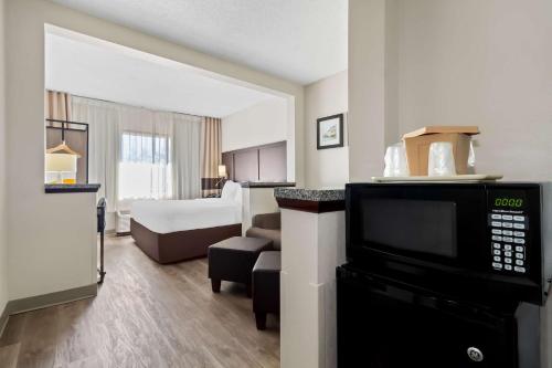 a hotel room with a television and a bedroom at Comfort Suites Lumberton North in Lumberton