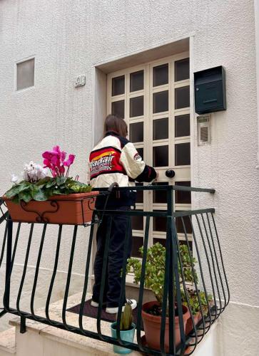 a woman standing on a balcony with a flower pot at Centro Storico Di Tea in Turi