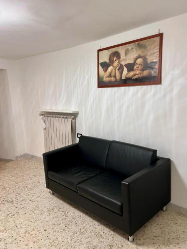 a black couch in a room with a painting on the wall at Centro Storico Di Tea in Turi
