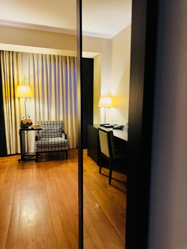 a hotel room with a desk and a table with a chair at Hotel Rivo Timisoara in Timişoara
