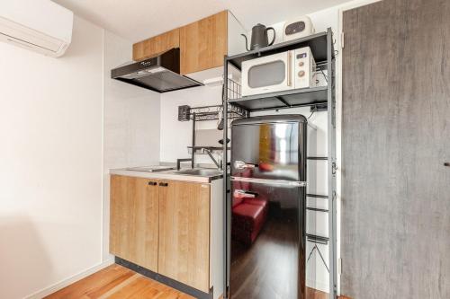 a kitchen with a refrigerator and a microwave at jtr浅草橋302 in Tokyo