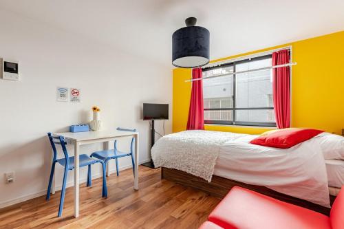 a bedroom with a bed and a desk and a window at jtr浅草橋302 in Tokyo