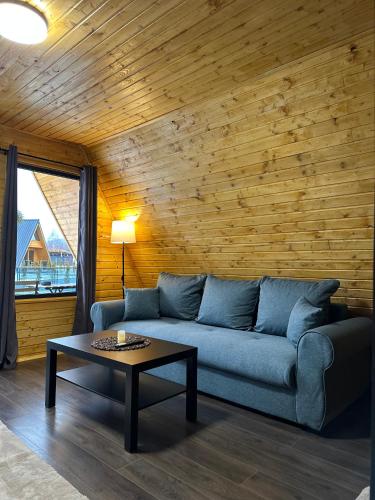 a living room with a blue couch and a table at PRIVATE PLACE Avrig adults only in Avrig