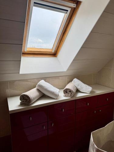 a bathroom with a window and towels on a counter at Charmante maison familiale in Ouistreham