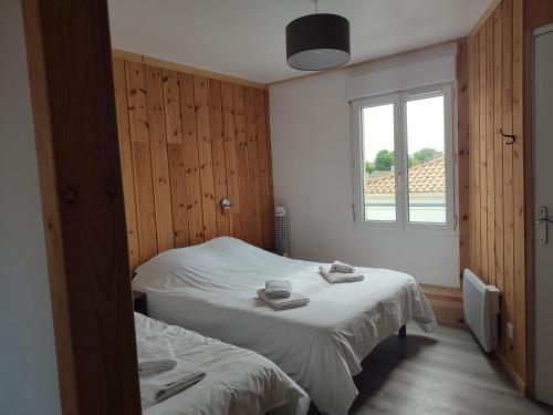 a bedroom with two beds and a window at La Marie Galante Appart'Hotel in Saint-Georges-dʼOléron