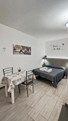 a room with a bed and a table with a bench at Da Nenè in Cefalù