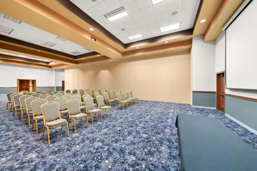 a conference room with a row of chairs and a screen at Clarion Inn & Suites and Convention Center in Kearney
