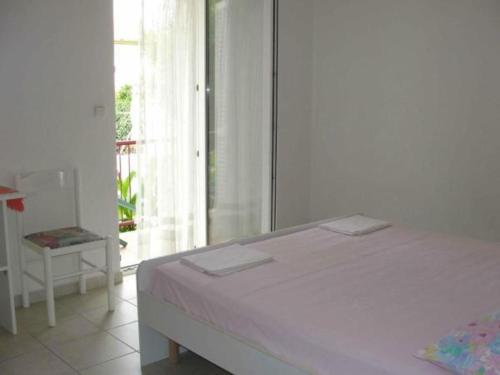 a white bedroom with a bed and a balcony at Apartments Boguvila - One-Bedroom Apartment with Terrace A3 - ST in Supetar