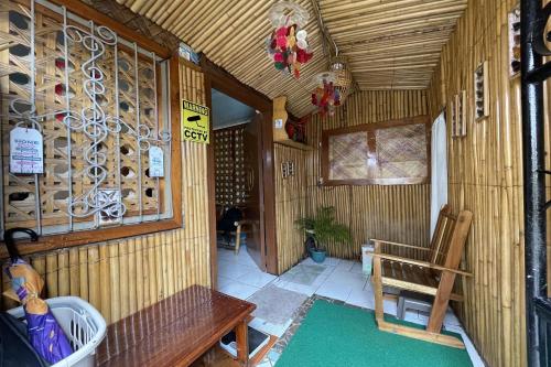 a room with a bench and a wall of wine bottles at Balai Vivencio Hostel in Puerto Princesa City