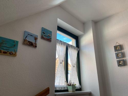 a window with a curtain in a room at De Lütte Nest in Waren