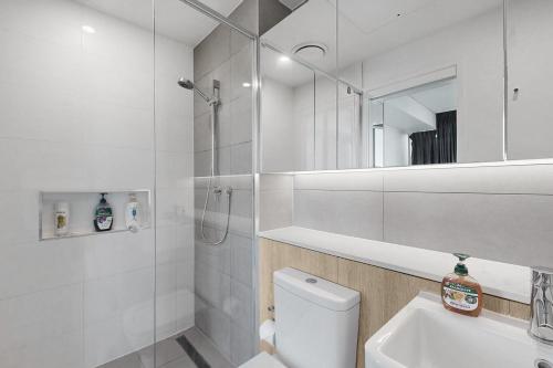 a bathroom with a shower and a toilet and a sink at Urban Luxe Retreat - South Brisbane Boutique Apt w Free Carpark in Brisbane